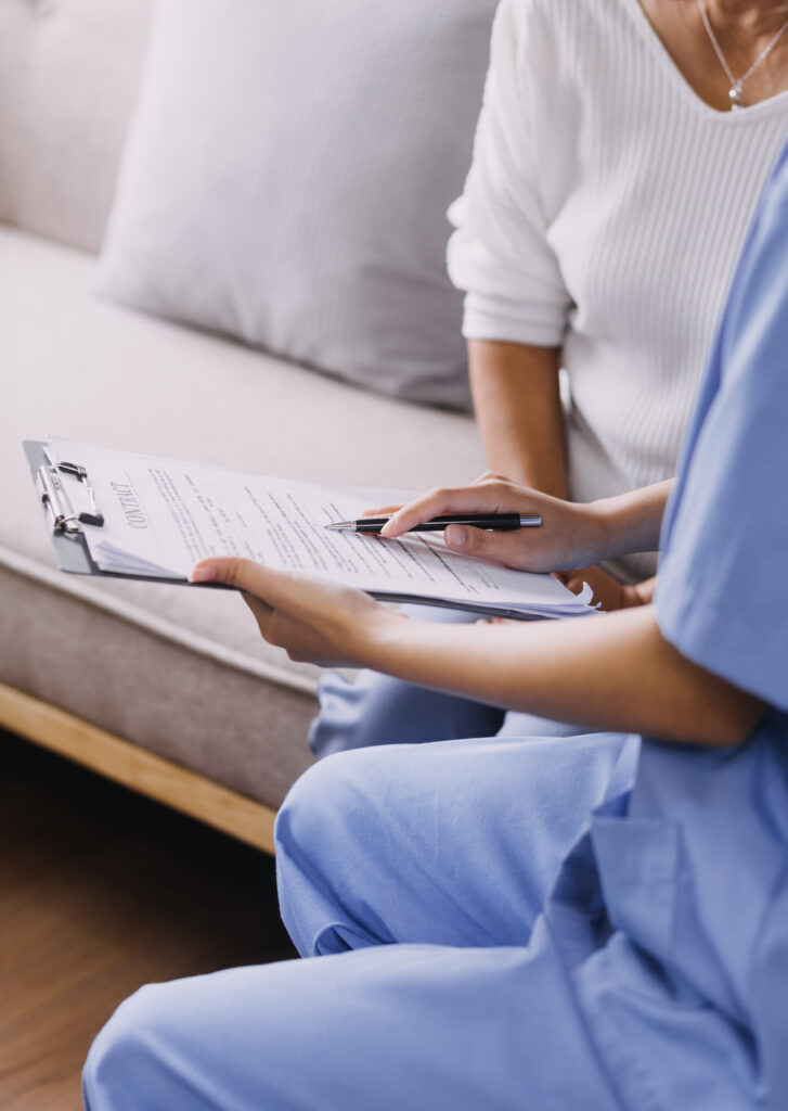 Nurse Filling Out Form With Patient HIPAA Compliance Consulting Services