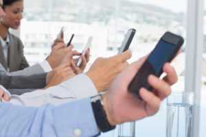 Employees Holding Phones - Mobile Device Management (MDM)