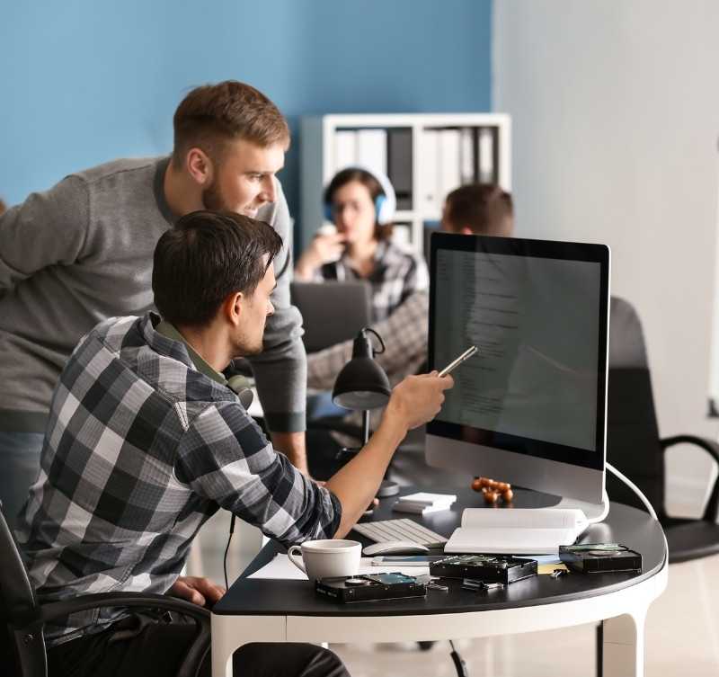 IT Professionals Collaborating And Reviewing Code