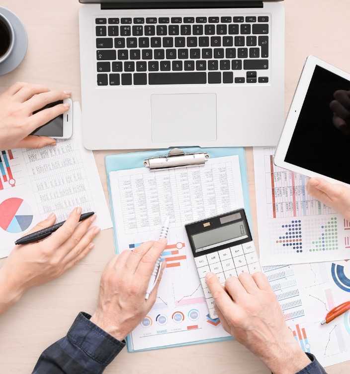 Professionals Working On Reports With Laptop