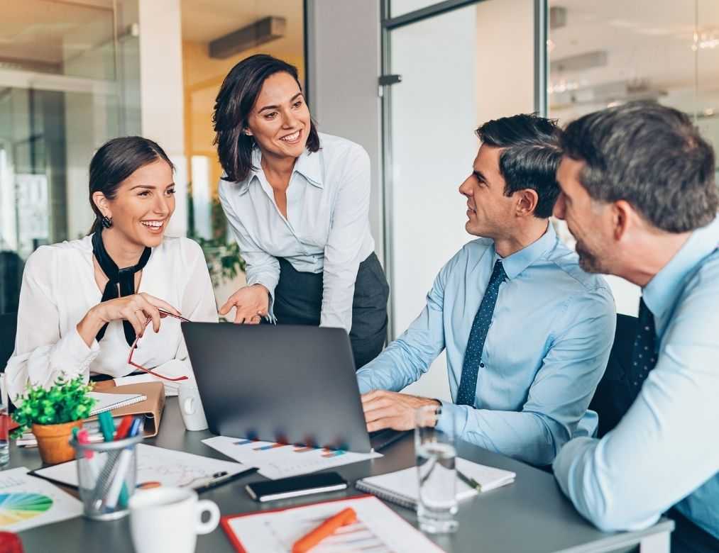 Corporate Team Brainstorming With Laptops And Coffee In Modern Office