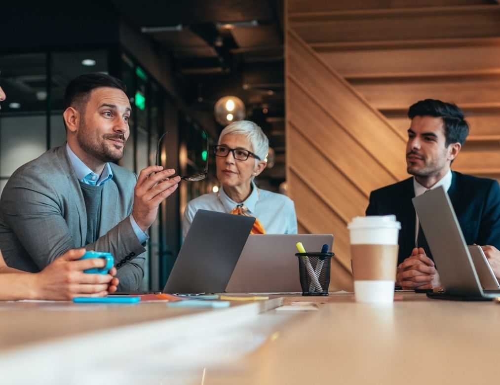 Group Of Business Professionals Discussing Strategy With Smiling Woman