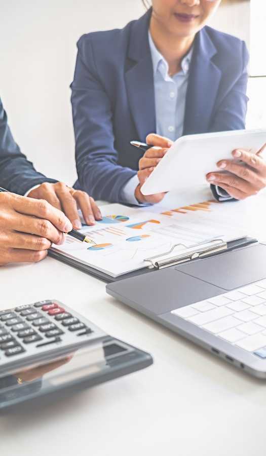 Professionals Working With Reports On Workplace Table