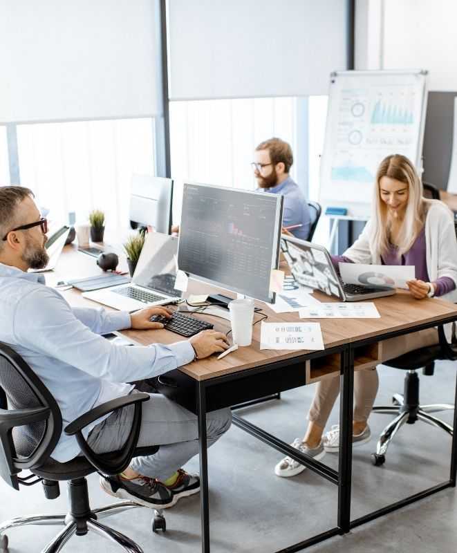 Three professionals working on laptops in a  office