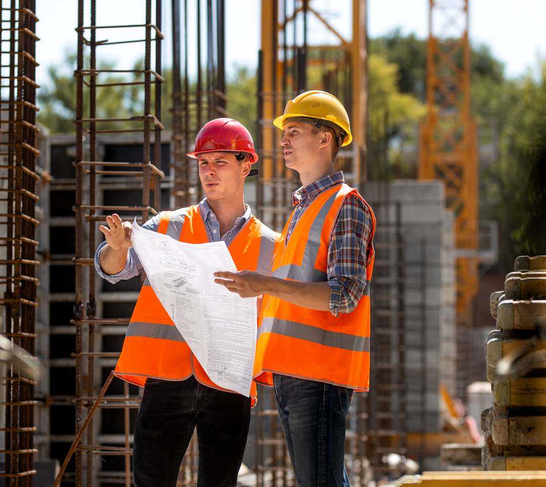  Engineers Reviewing Construction Plans On Site<br />
