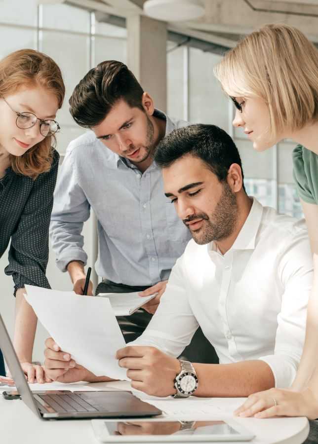  IT Professionals Reviewing Documents At Office 